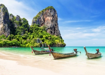 Thai traditional wooden longtail boat and beautiful sand Railay Beach in Krabi province. Ao Nang, Thailand.