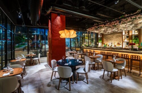 Interior of Mita with floor to ceiling windows and a sophisticated bar