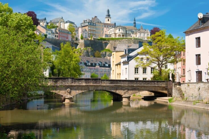 A bridge in Luxembourg with the city rising behind it.