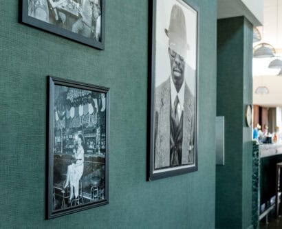 Photos of Black people hang on a green wall at Sly Rooftop in Washington, DC