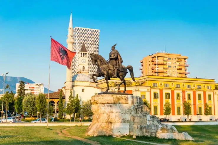 A statue and a flag in an Albanian square